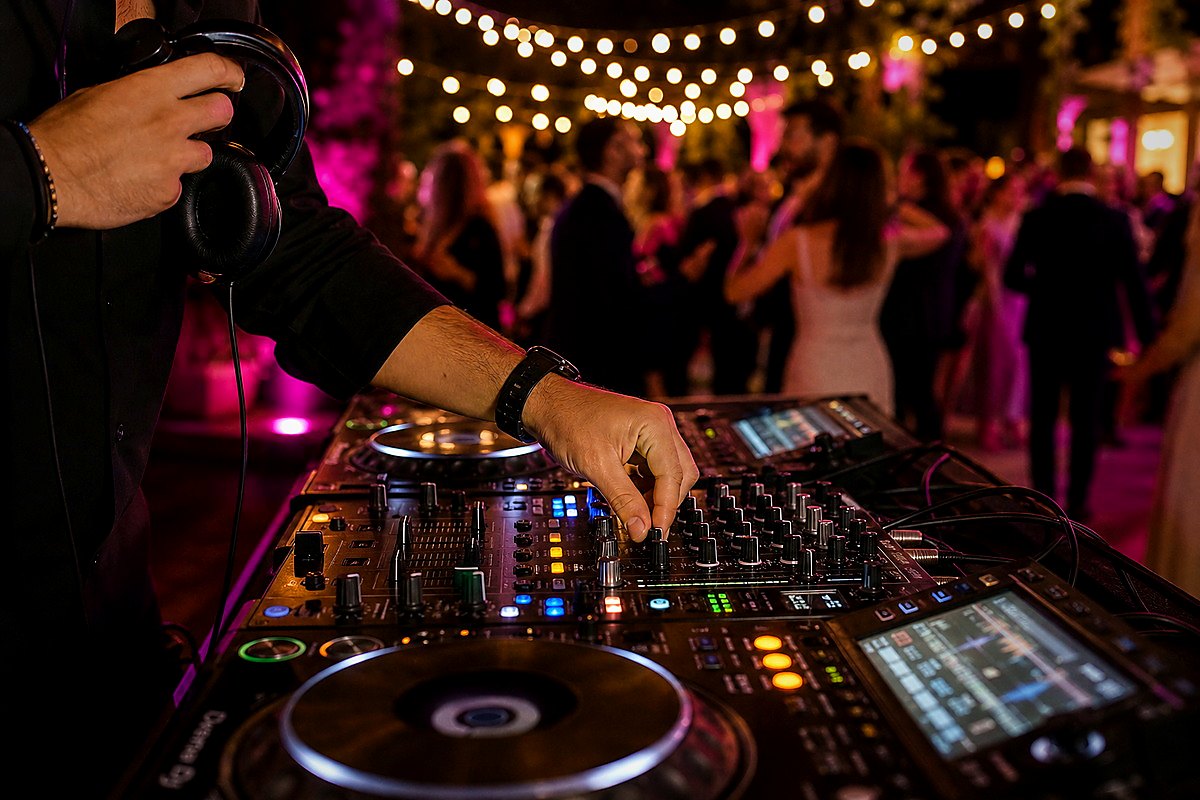 Mesa de DJ durante una celebración con invitados al fondo